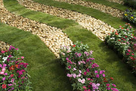 Small stones have been used in these flower beds instead of natural mulch to create a sophisticated feel to this garden